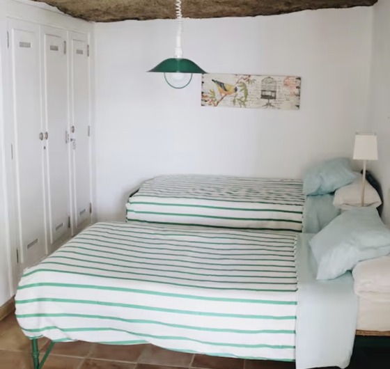 A bright shared bedroom with two beds at the villa